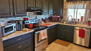 Una cocina moderna con armarios oscuros, un microondas, un tostador y una estufa.