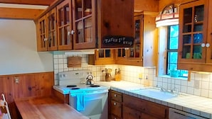Una cocina con armarios de madera, una mesa de madera y una ventana con vistas.