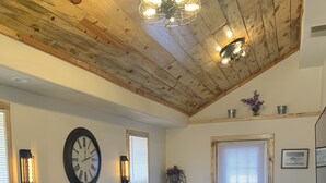 Ein Wohnzimmer mit einem Ecksofa, einem gemusterten Teppich und einer Holzzahl.