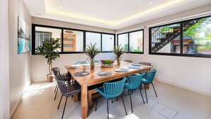 Un espace repas moderne avec une table en bois, des chaises bleues et des plantes en pot.