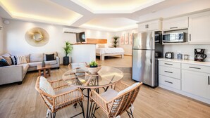 Un appartement moderne comprenant un coin repas, une cuisine, un salon et une chambre.