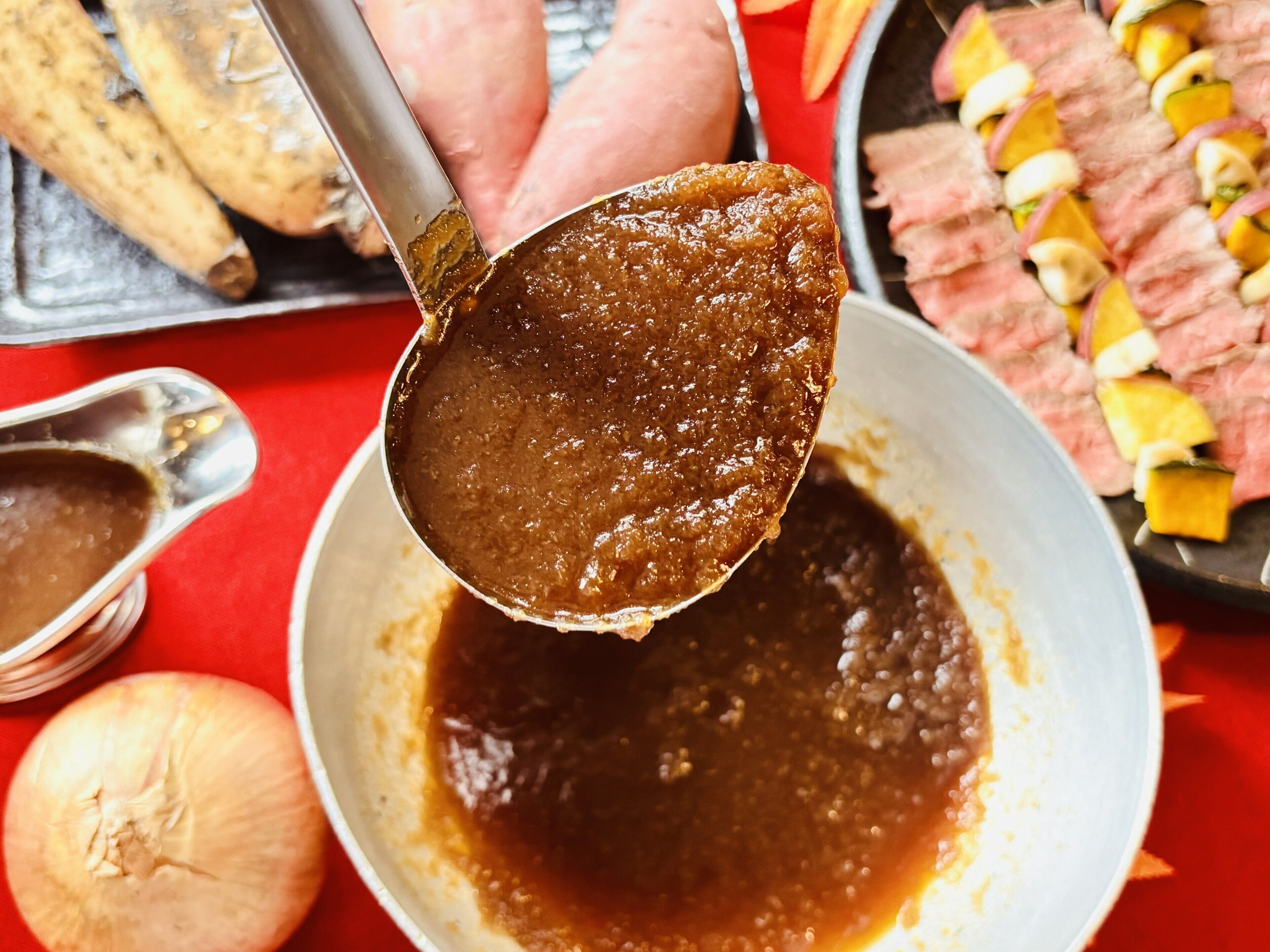 Una cucharada de salsa oscura y espesa siendo levantada de un tazón.