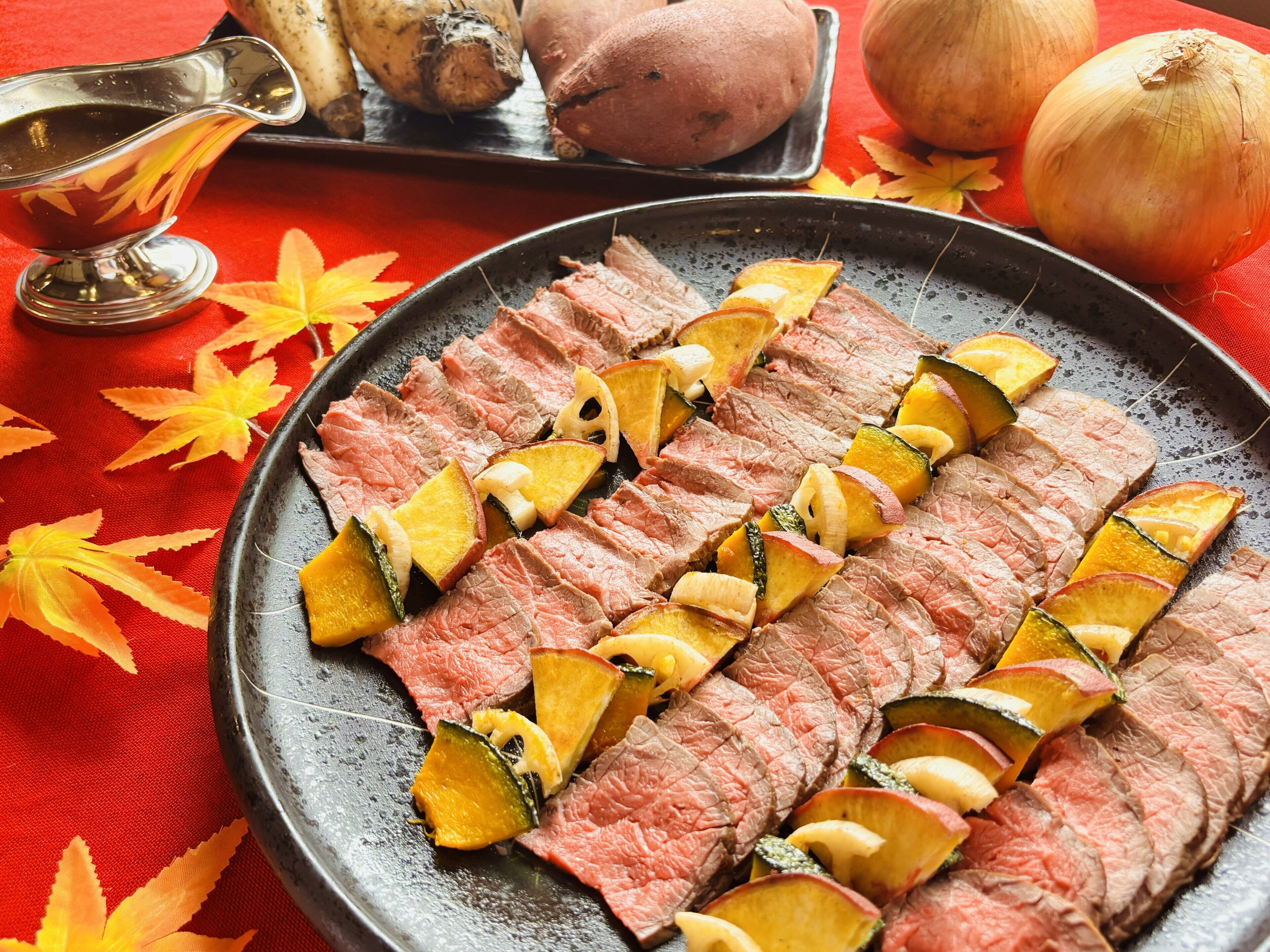 A plate of sliced meat with vegetables on a table.