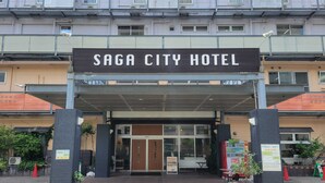 The entrance of Saga City Hotel with a covered walkway, potted plants, and a signboard. - Saga City Hotel (Saga)