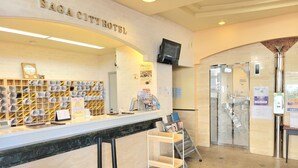 A reception area at SAGA CITY HOTEL with a marble counter, a clock, and a wall-mounted TV. - Saga City Hotel (Saga)