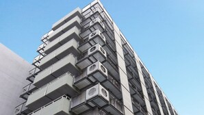 A high-rise building with multiple balconies and air conditioning units. - Saga City Hotel (Saga)