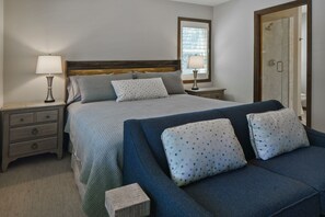 A bedroom with a bed, two bedside tables, a nightstand, a dresser, a sofa, and a mirror. - NEW Private 3 acre waterfront property directly on the Bay! WEEKLY DISCOUNT 10% (Sturgeon Bay)