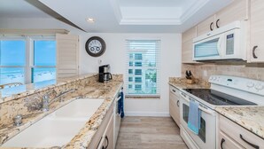 A modern kitchen with granite countertops, a built-in oven, and a microwave.