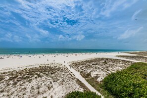 Na praia, espreguiçadeiras, toalhas de praia 
