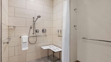 Un baño moderno con ducha, perchero y un taburete pequeño.