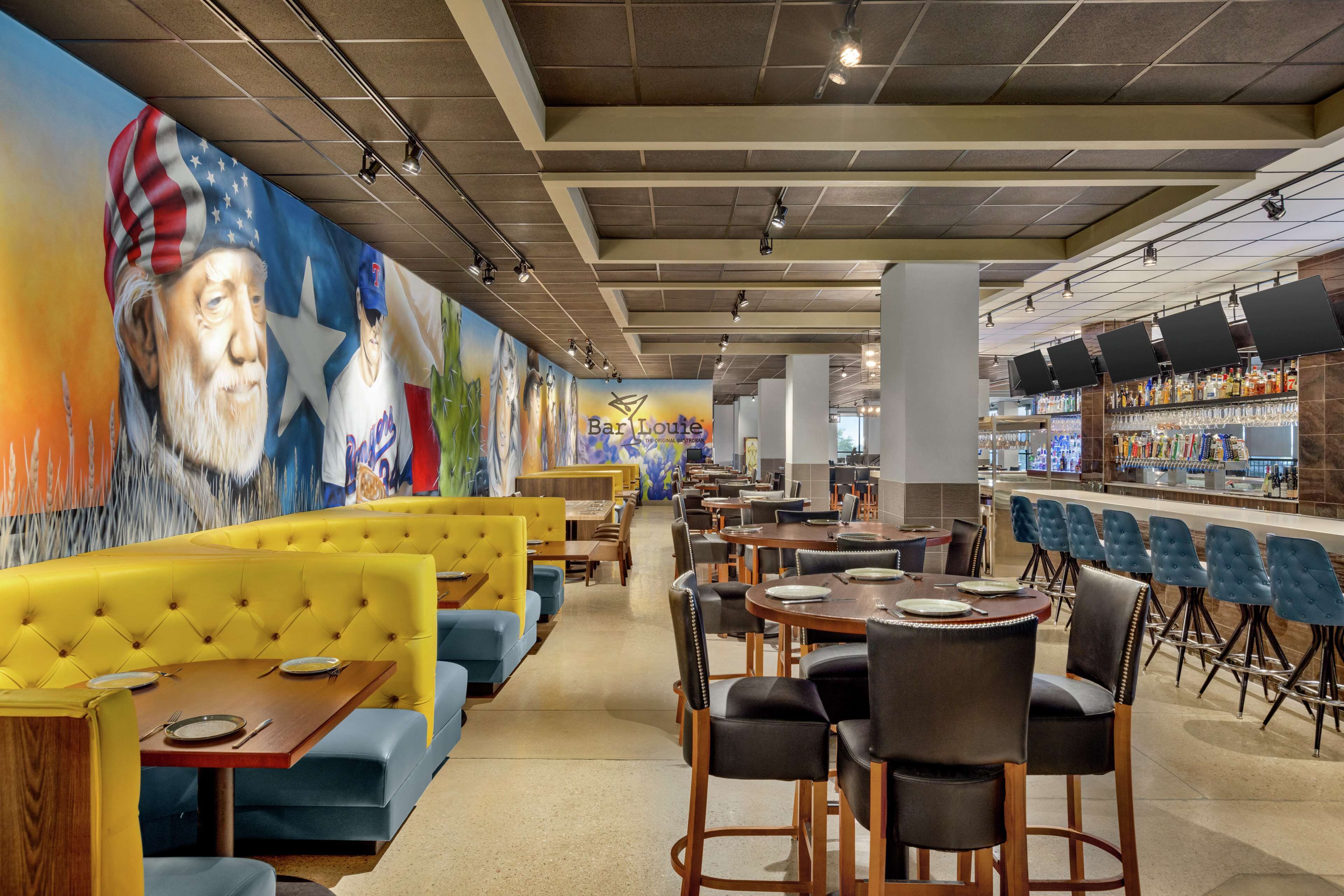 Un restaurante con cabinas, mesas y una zona de bar.