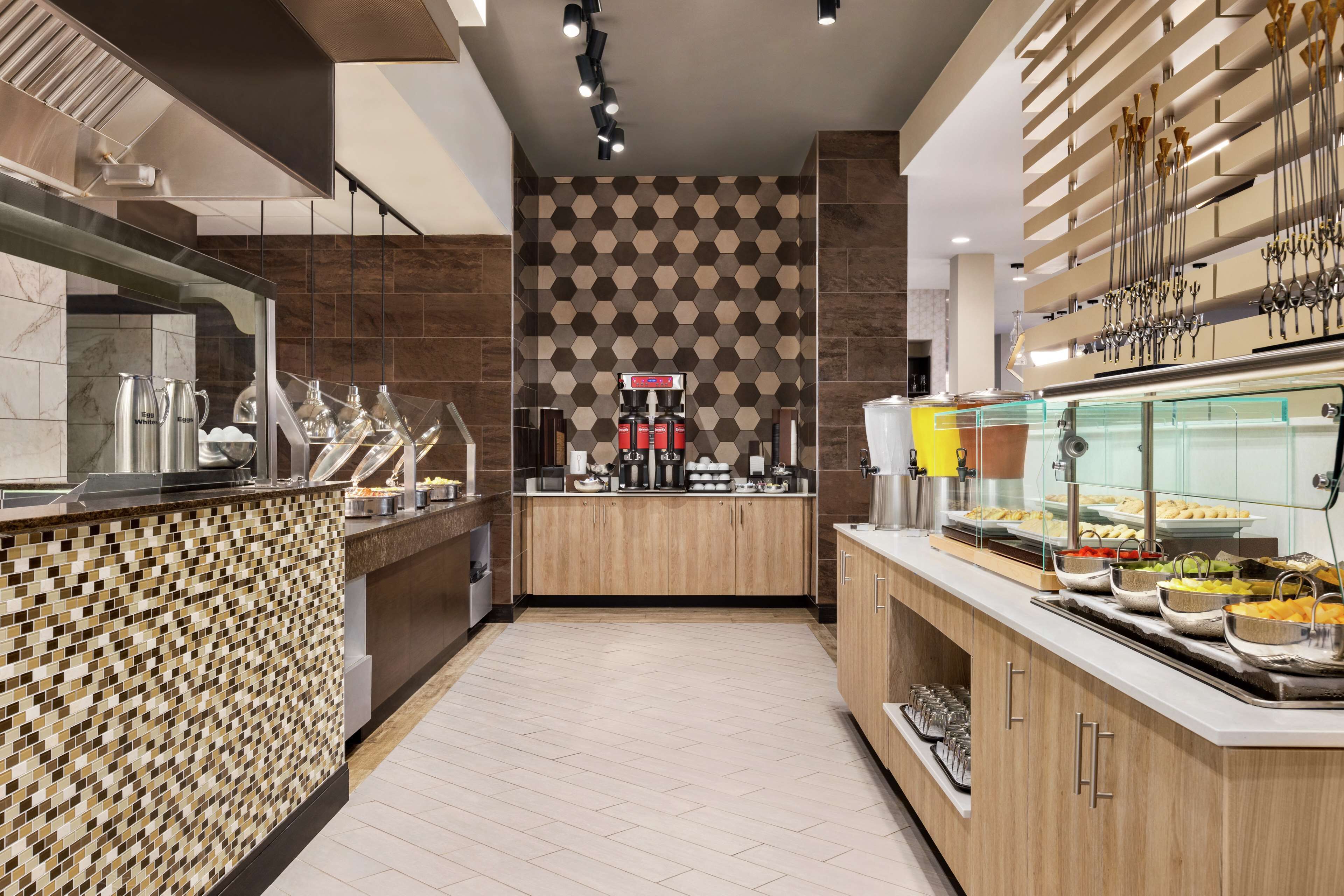 A modern kitchen with a central island, a coffee machine, and various food items displayed on the counter.