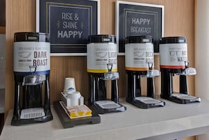 Una estación de café con cinco dispensadores diferentes, cada uno identificado con un tipo de tueste único.