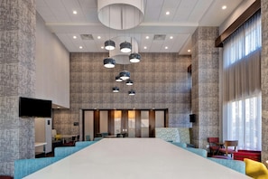 A spacious conference room with a long table, multiple chairs, and a modern ceiling design.