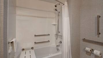 A modern bathroom with a bathtub, shower, and toilet.