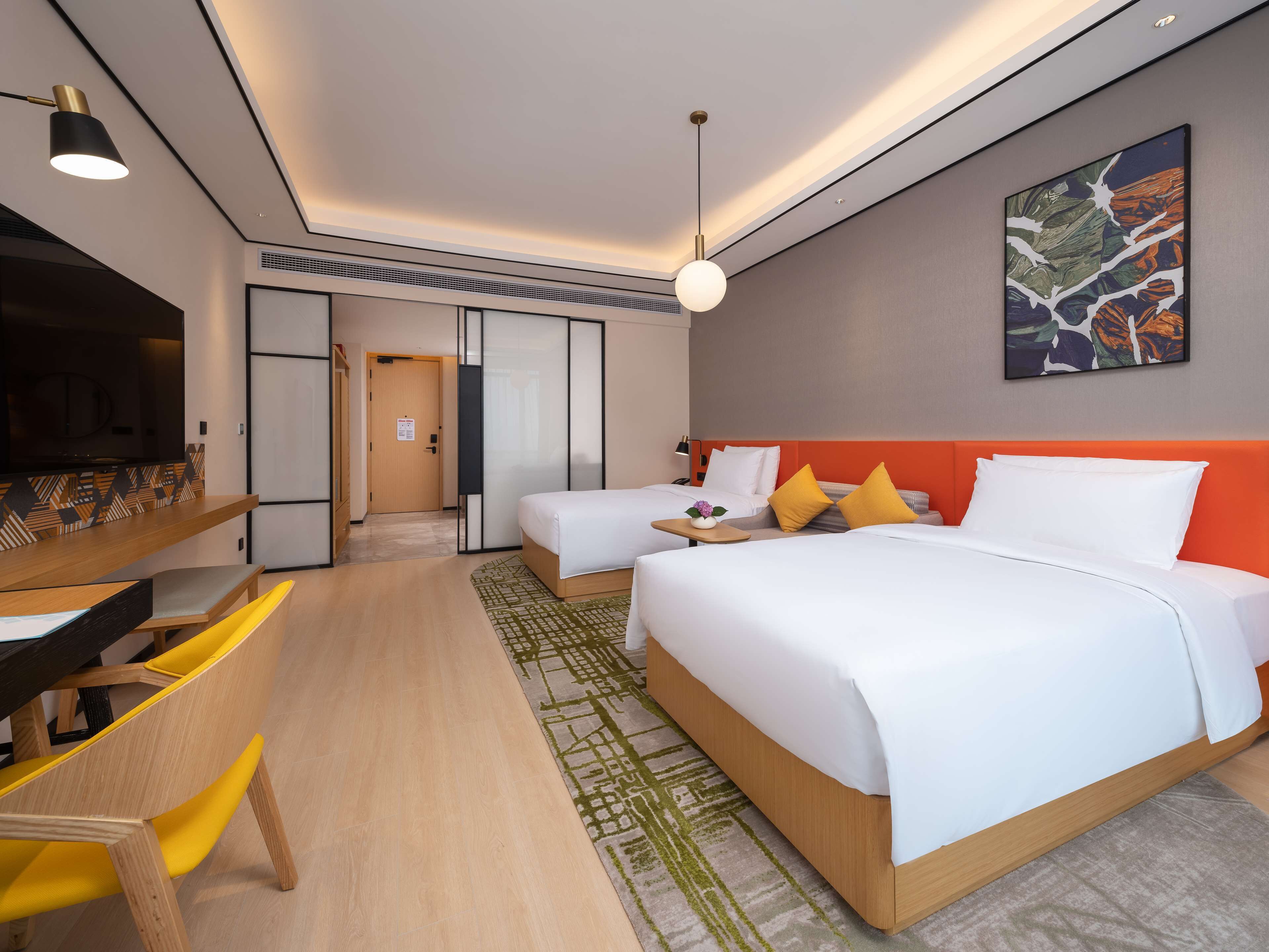 Una habitación de hotel con cama, mesita de noche y televisión.