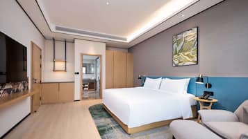 Una habitación de hotel moderna con una cama grande, un escritorio, una silla y un televisor.