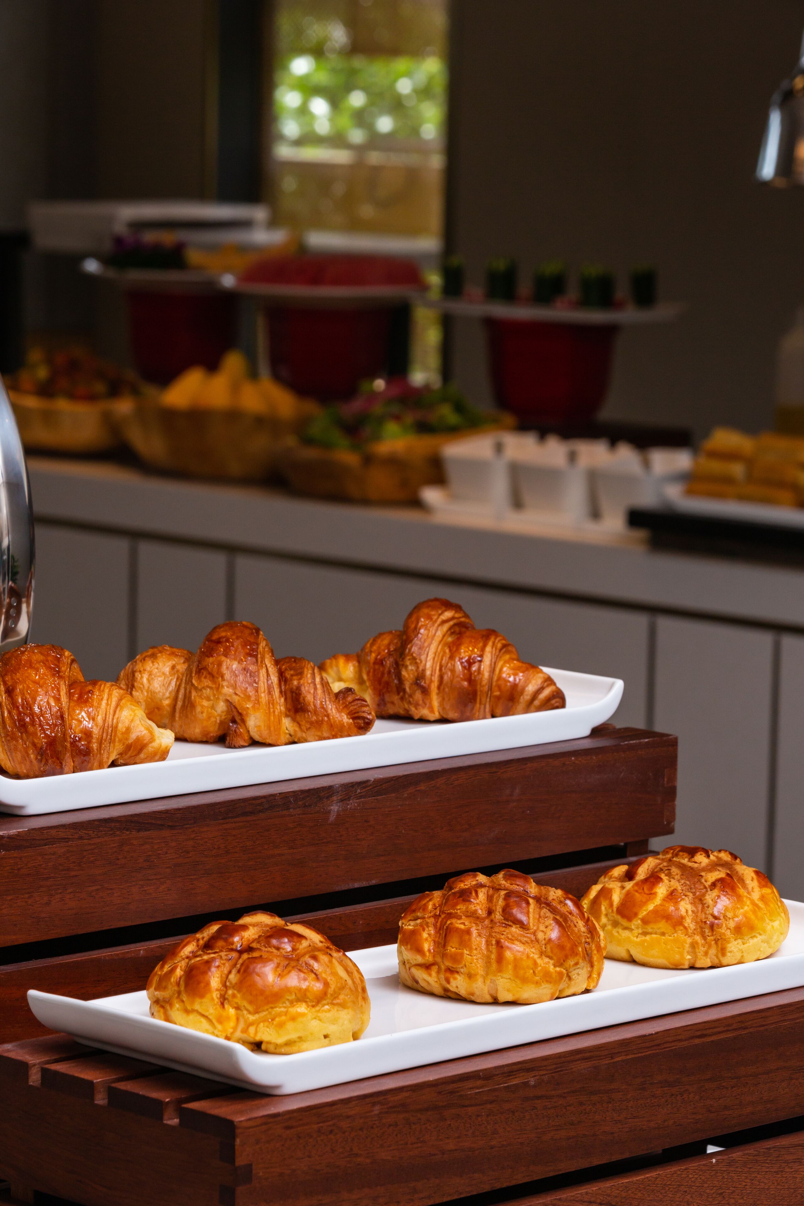 A buffet table with croissants and other baked goods.