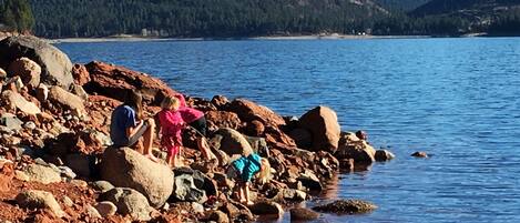 Una costa rocosa con grandes rocas y un lago tranquilo.