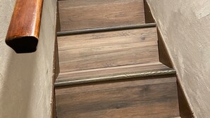 Eine Holztreppe mit Handlauf, die zu einer oberen Etage führt.