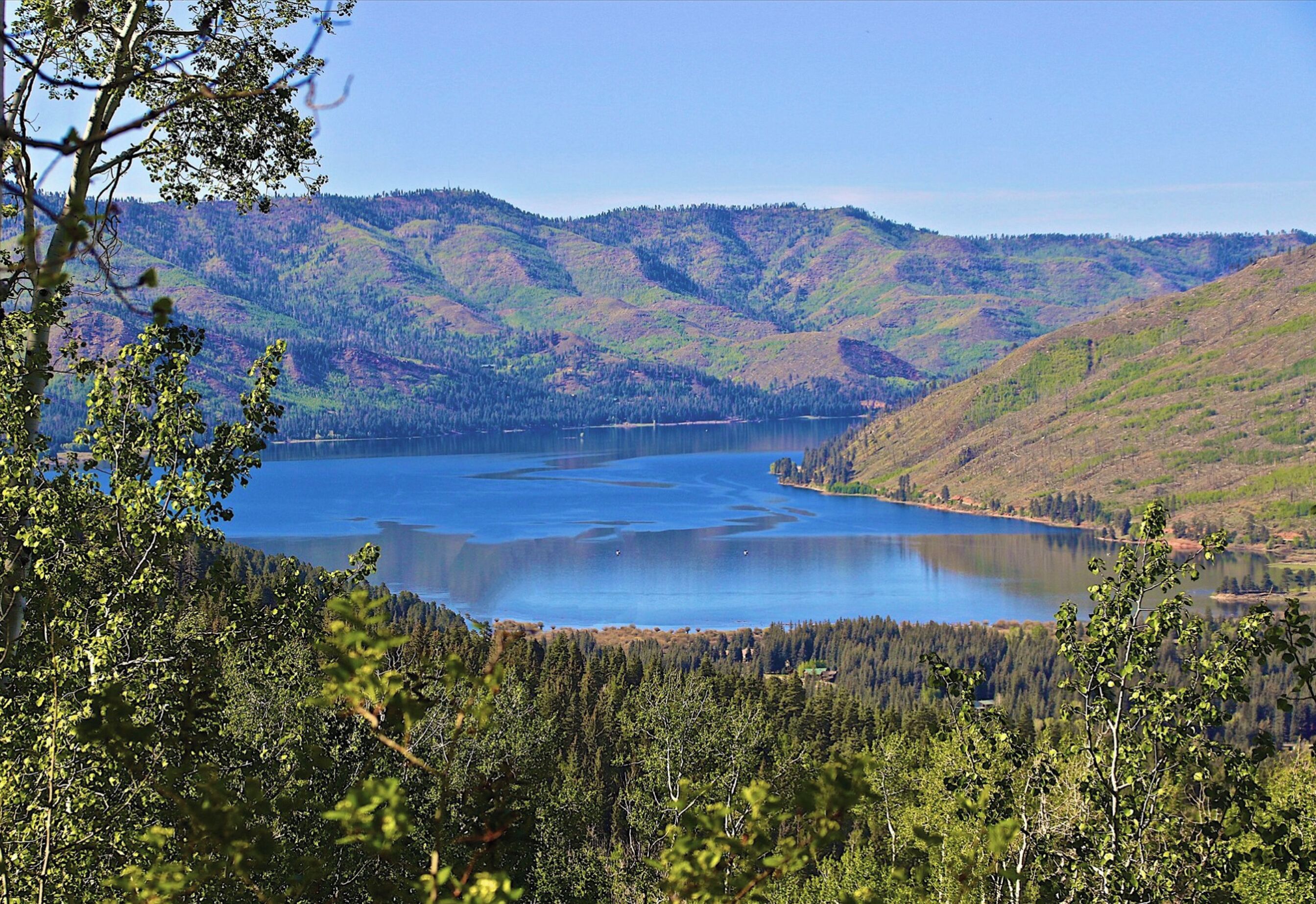 Un lago rodeado de colinas boscosas.
