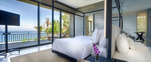 A modern bedroom with a large bed, a sofa, and a view of the ocean. - Bali Villa 1082: Cliffside Luxury with Ocean Views (Bali)