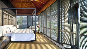 Een moderne slaapkamer met een groot bed, nachtkastjes en uitzicht door middel van ramen van de vloer tot aan het plafond.