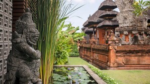 A traditional Balinese temple with intricate carvings and a pond with lotus flowers. - Stylish Beachside Villa with Pool & Stunning Views – Bali Villa 1068 (Bali)