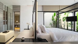 Une chambre moderne avec un grand lit, une table de chevet et une vue sur la verdure.