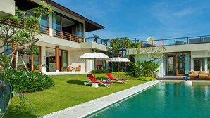 A modern house with a swimming pool, two lounge chairs, and a covered seating area. - Bali Villa 1029: Where Luxury Meets the Sky (Bali)