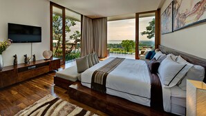 A modern bedroom with a large bed, a TV, a wooden console, and a balcony with a view. - Bali Villa 1029: Where Luxury Meets the Sky (Bali)