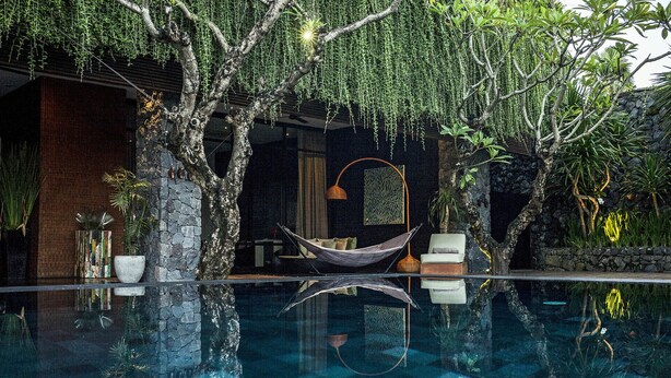 A serene indoor pool area with a hammock, stone walls, and lush greenery. - Luxury Villa Escape with Exceptional Staff – 1028 (Bali)