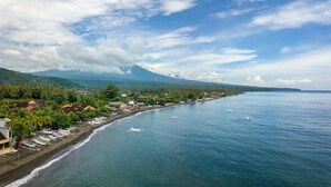 A coastal town with a beach, boats, and a mountain in the background. - Serenity by the Shoreline – Bali Villa 1048 (Bali)