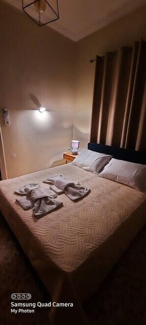 Relax in this inviting room with a comfortable bed, bedside table, and ceiling fan.