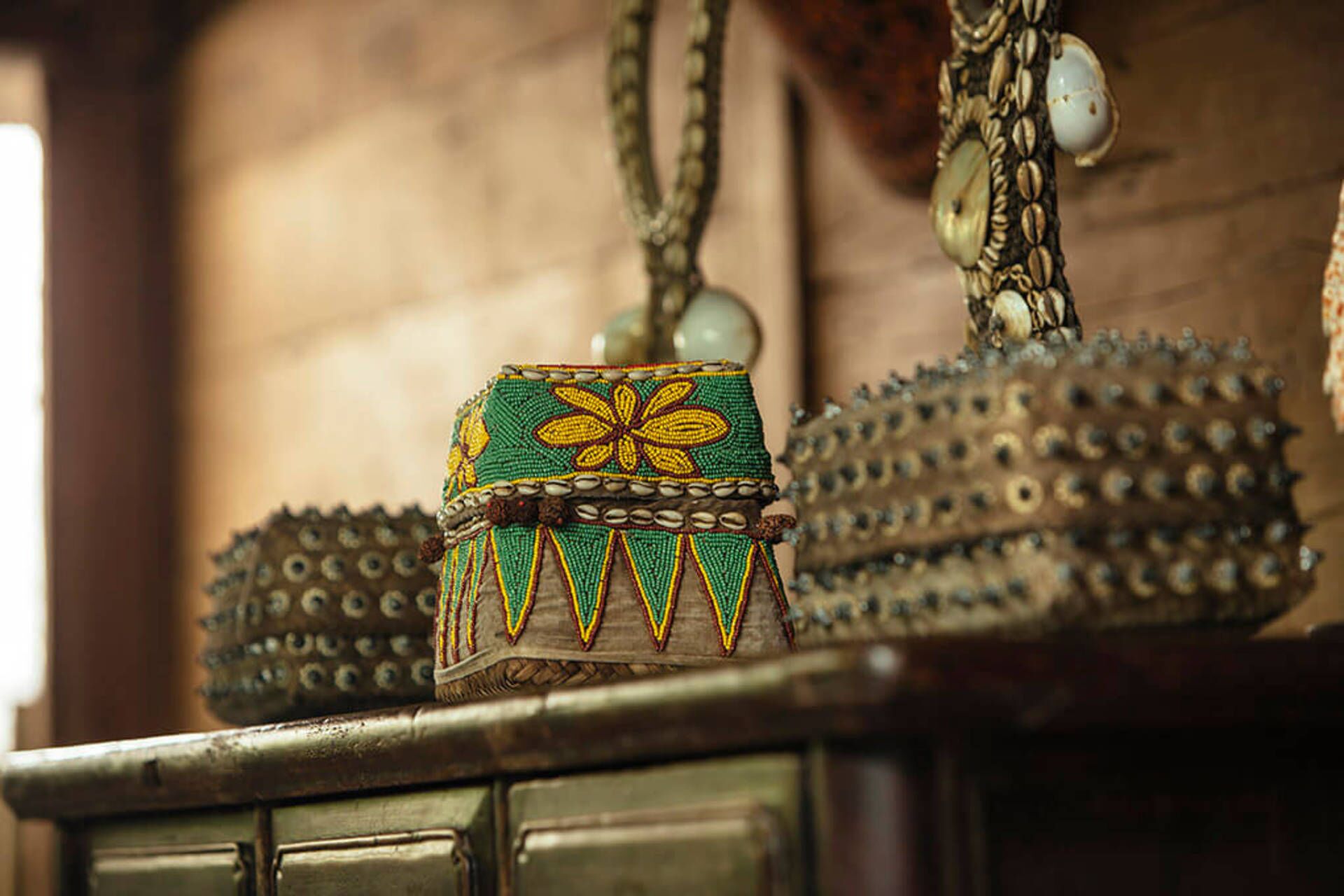Un panier traditionnel en osier, orné d’un motif floral décoratif, et suspendu à une chaîne.