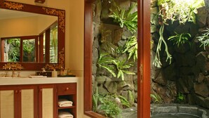 A bathroom with a stone wall, a sink, and a bathtub.
