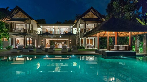 Ein großes, modernes Haus mit Swimmingpool, mehreren Sitzbereichen im Freien und einer überdachten Terrasse.