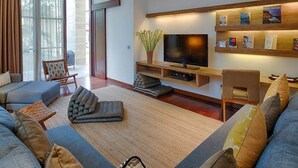 Ein modernes Wohnzimmer mit einer Couch, einem Couchtisch, einem Fernseher und einem Bücherregal.