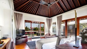 A spacious bedroom with a large bed, a TV, and a balcony with a view of the surroundings. - Exclusive Luxury Villa with Pool & Entertainment – Bali Villa 1059 (Bali)