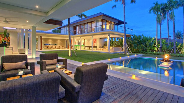 A modern outdoor pool area with lounge seating and a two-story building in the background. - Exclusive Luxury Villa with Pool & Entertainment – Bali Villa 1059 (Bali)