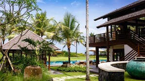 A resort with a pool, lounge chairs, and a tropical garden.