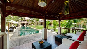 A covered outdoor area with a pool, wooden deck, and outdoor seating. - Escape to Bali Villa – Ubud’s Premier Sanctuary 1000 (Bali)