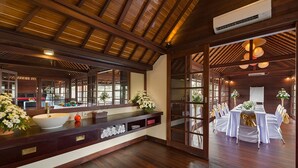 A spacious room with a large wooden ceiling, a central sink with a mirror, and a dining area with white tablecloths and chairs. - Escape to Bali Villa – Ubud’s Premier Sanctuary 1000 (Bali)