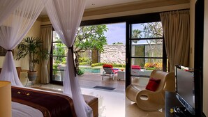Un dormitorio con cama, televisor y vistas a un área de piscina al aire libre.