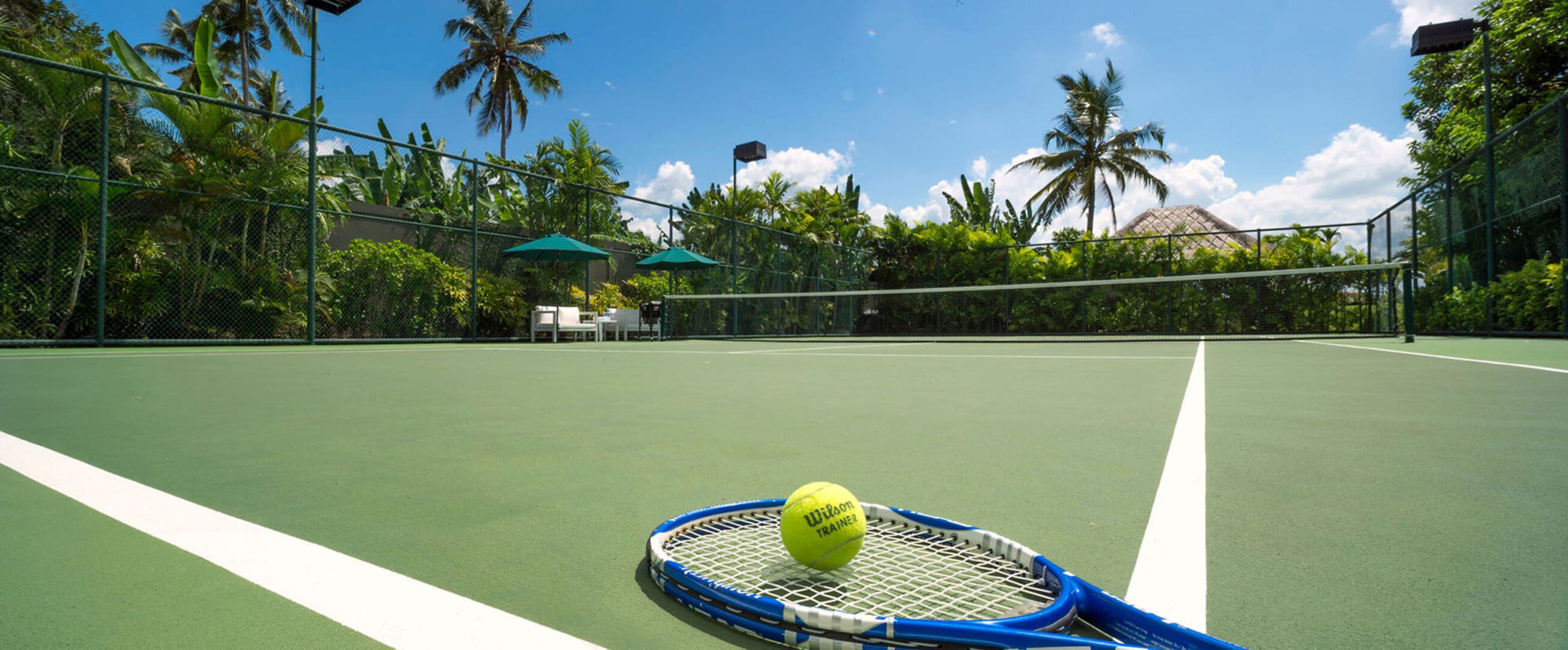 Un court de tennis avec un filet, une balle de tennis et une raquette.