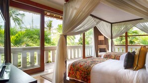 A bedroom with a canopy bed, a view of palm trees, and a balcony with a railing. - Elegant Estate with Private Pool - Bali Villa 1007 (Bali)