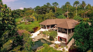 A villa with a pool, surrounded by lush greenery and palm trees. - 5 Star Villa in Bali, Minutes from the Beach, Bali Villa 1026 (Bali)