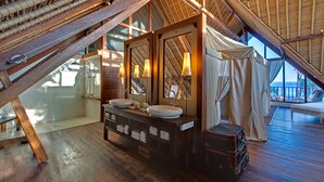 Ein Badezimmer mit einem Holzbidet, zwei Waschbecken und einer Dusche.