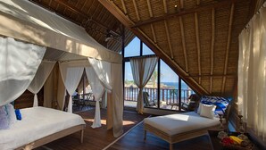 Ein Zimmer mit zwei Betten, einem Balkon und Meerblick.
