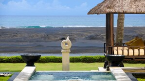 A pool with a decorative swan, a thatched-roof structure, and a view of the ocean. - Seaside Serenity with Private Pool – Bali Villa 1016 (Bali)